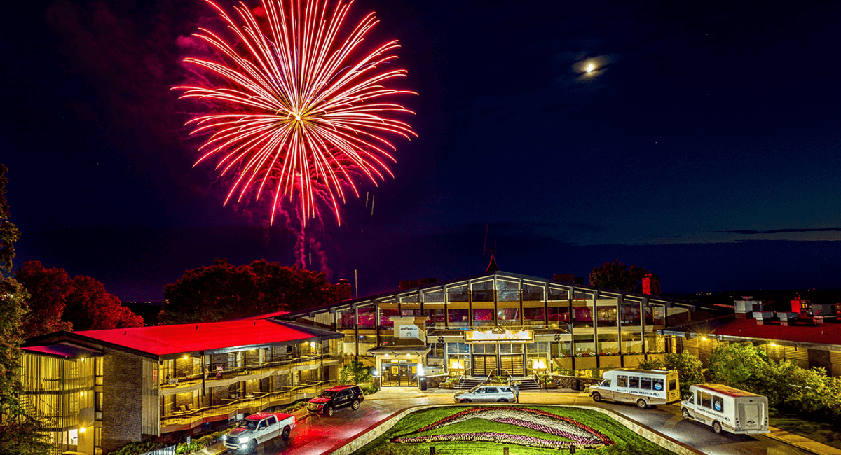 Red firework in the sky over The Lakeview Hotel at night.