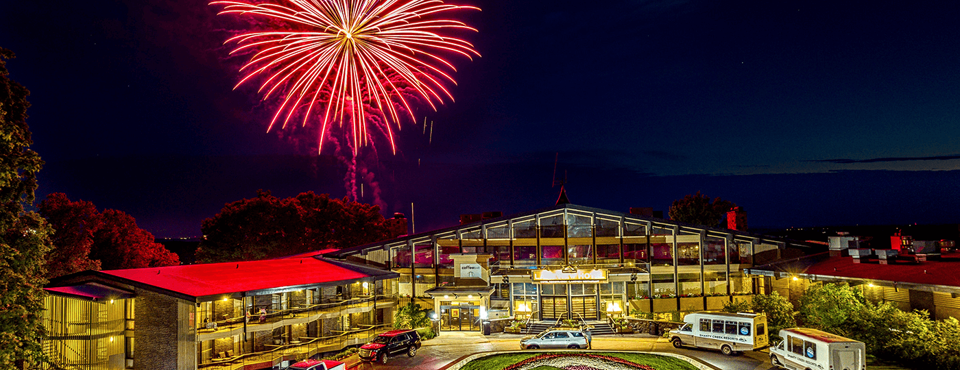 Red firework in the sky over The Lakeview Hotel at night.