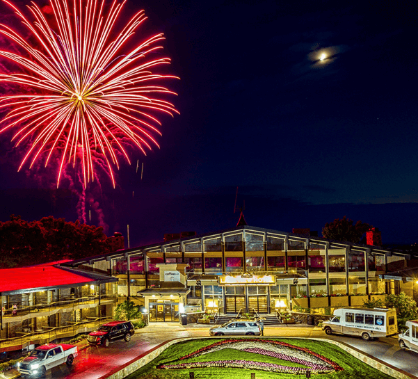 Red firework in the sky over The Lakeview Hotel at night.