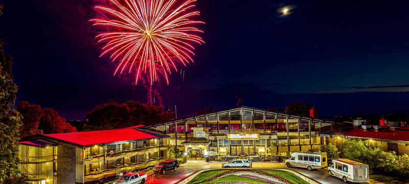 Red firework in the sky over The Lakeview Hotel at night.