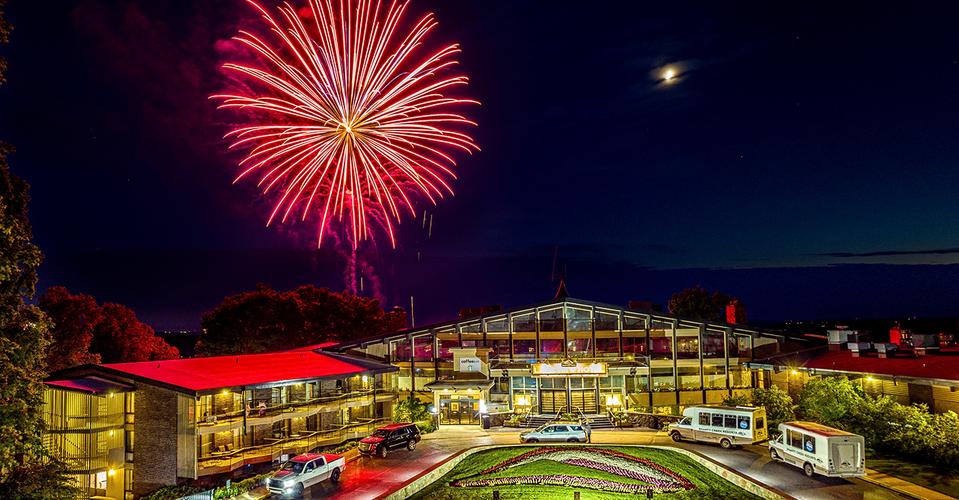 Red firework in the sky over The Lakeview Hotel at night.