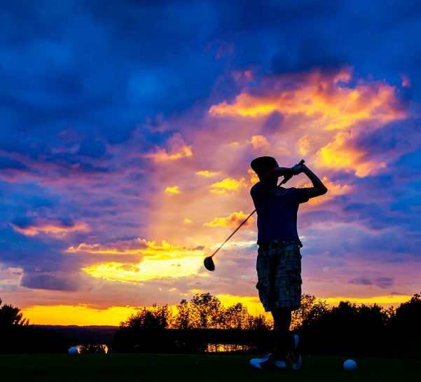 Man teeing off on The Legend hole 3 at Sunset