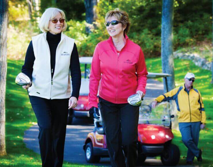 Pair of ladies walking with golf clubs