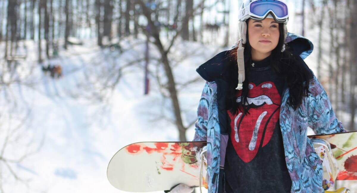 Female snowboarder holding board
