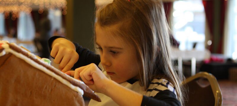 a young girl creates her gingerbread house at the annual workshop at shanty creek resort