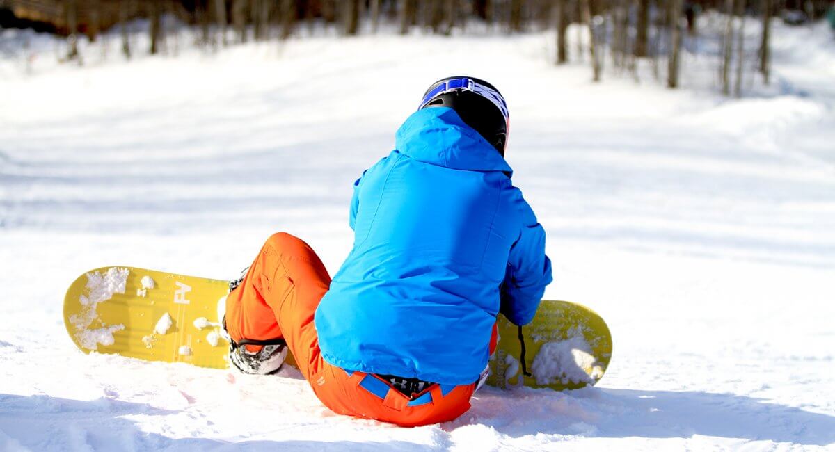 Snowboarder's back looking down the hill