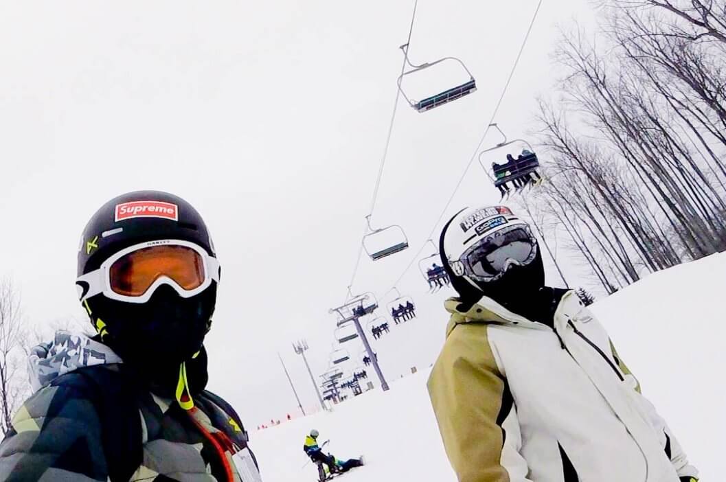 Two snowboarders under the purple lift