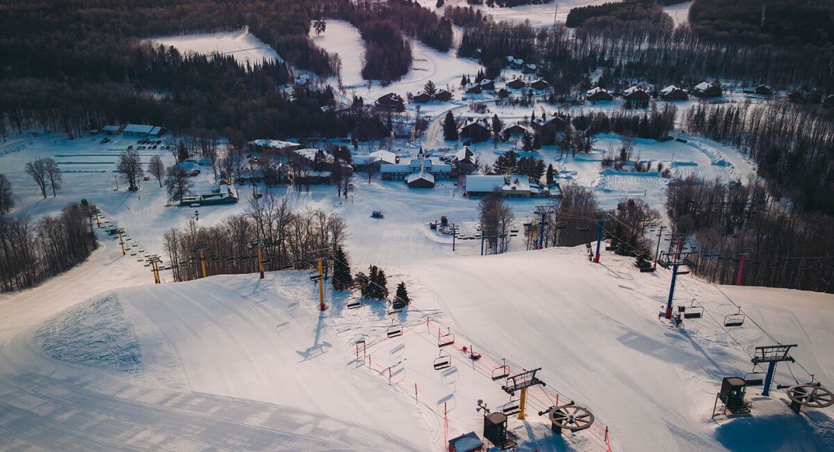 An aerial shot of the top of the yellow and blue chairlift at Schuss Mountain