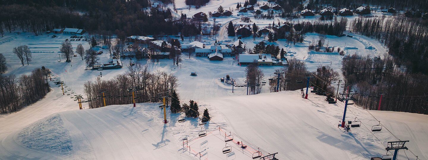 An aerial shot of the top of the yellow and blue chairlift at Schuss Mountain