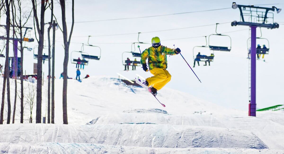 Colorful skier hitting a jump in the Monster Terrain Park