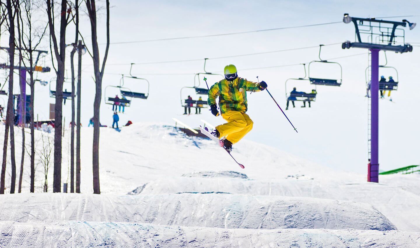 Colorful skier hitting a jump in the Monster Terrain Park