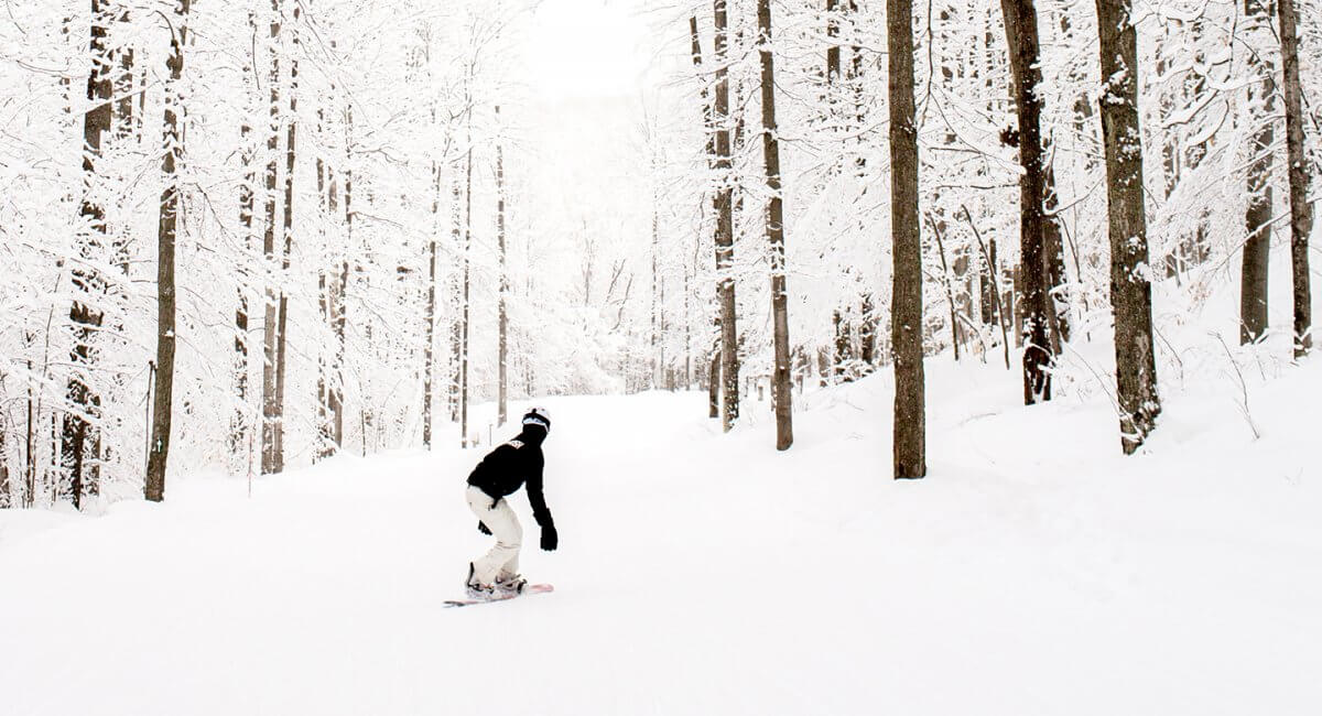 A snowboarder going down River Run