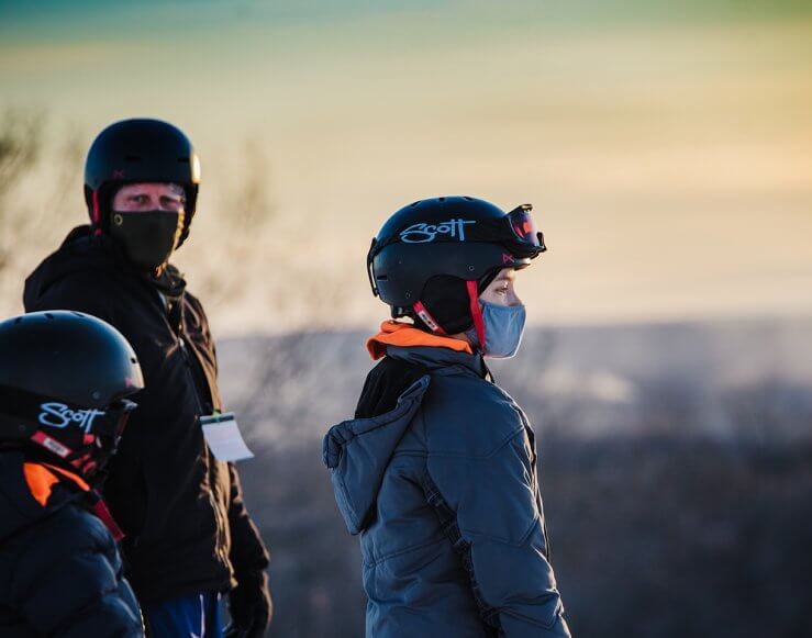 Father and sons looking at view on top of Schuss Mountain