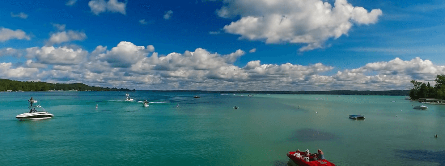 Torch Lake with red boat in foreground