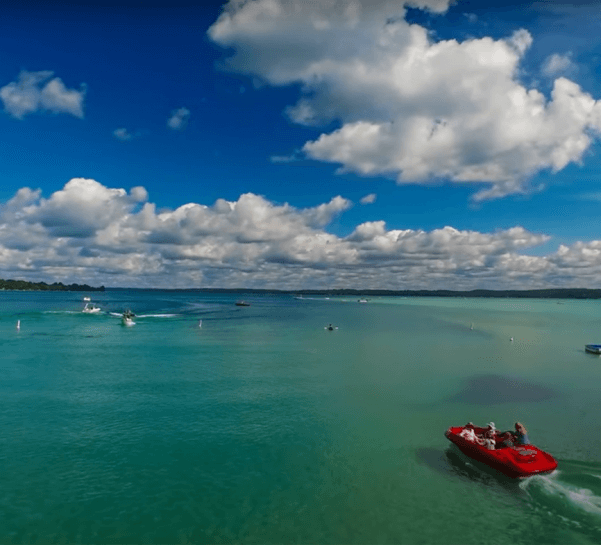 Torch Lake with red boat in foreground