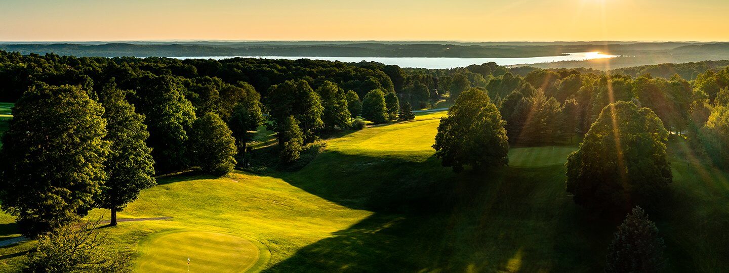Aerial of Summit GC Hole #11 Green and Hole #12 Tee looking towards Lake Bellaire in the background