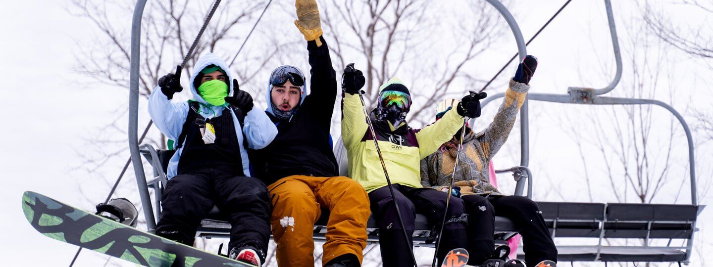 skier and boarders on chair lift