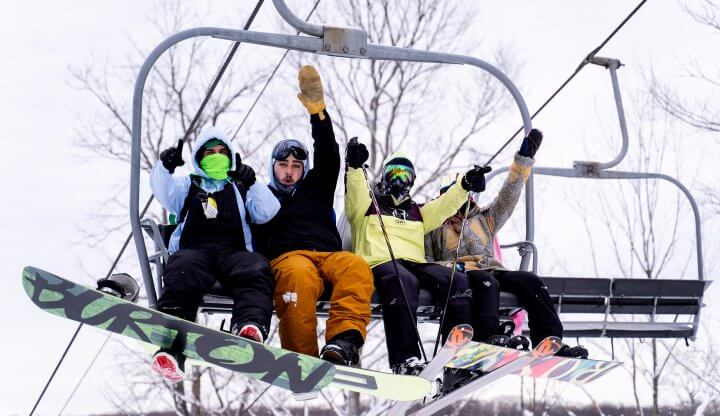 skier and boarders on chair lift