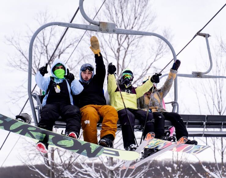 skier and boarders on chair lift