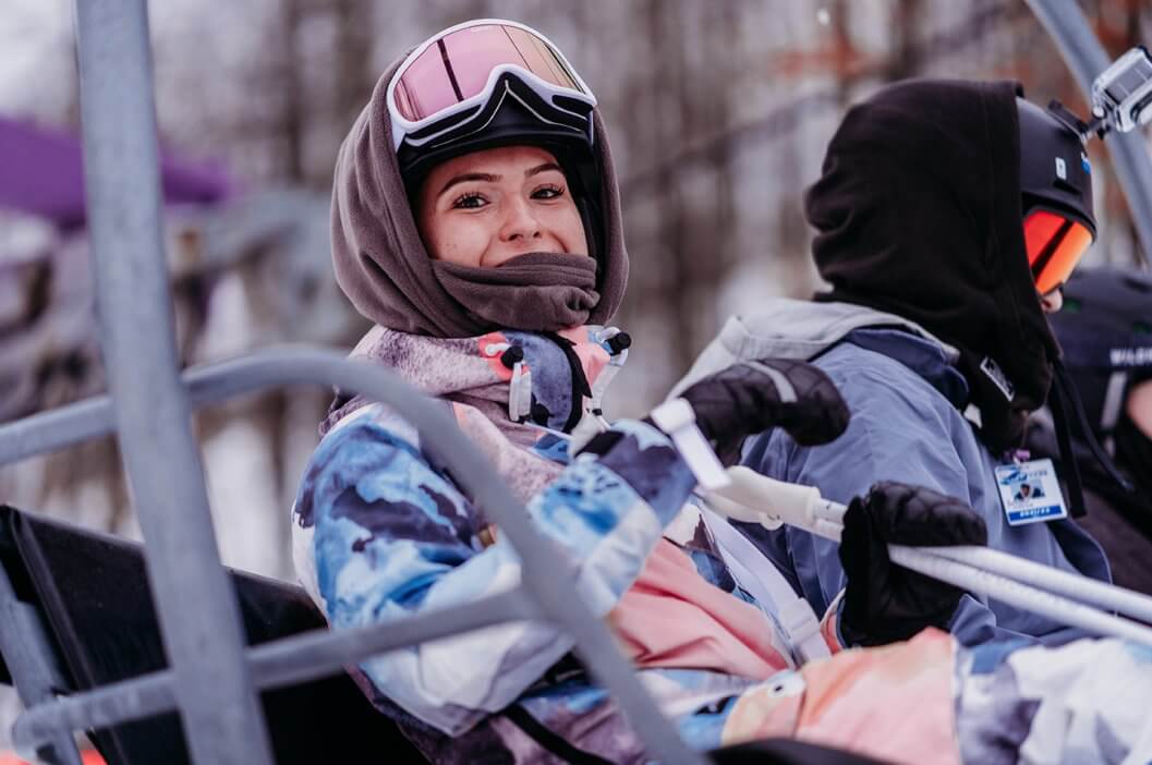 girl snowboarder smiling on ski lift