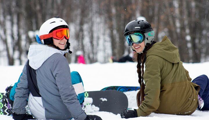Two snowboarders with helmets and goggles