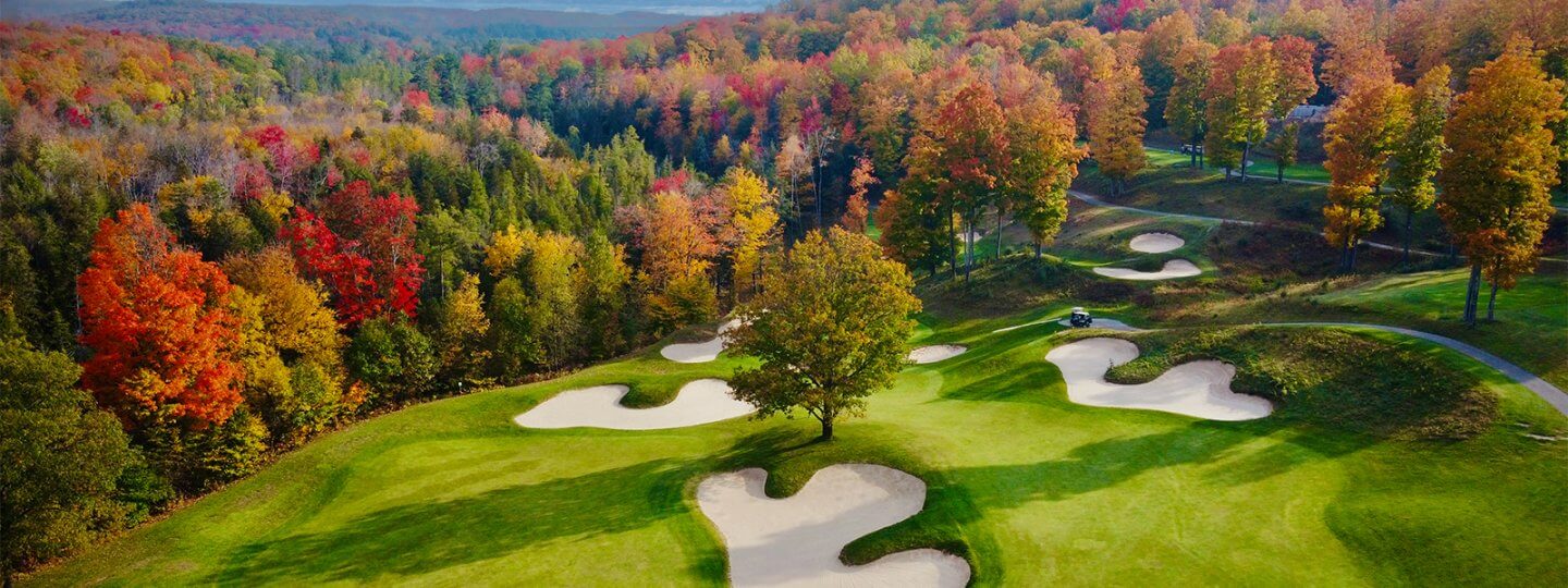 Aerial of Cedar River Hole 13's Green in the fall with colorful trees in the background
