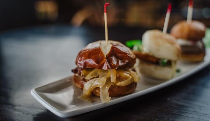 A trio of hamburger sliders on a table at The River Bistro