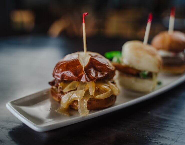 A trio of hamburger sliders on a table at The River Bistro