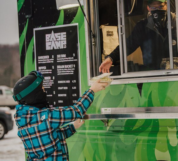 Skier being handed their meal from the Base Camp Food Truck