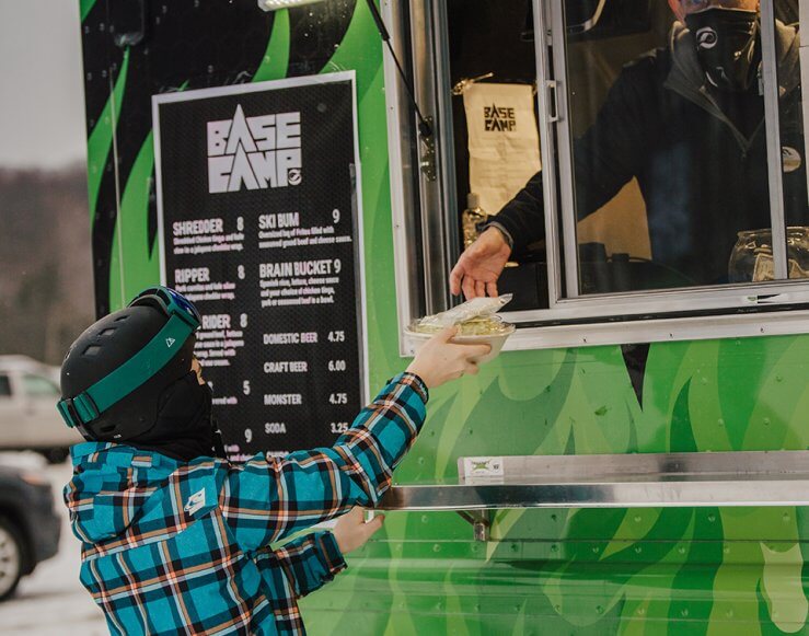 Skier being handed their meal from the Base Camp Food Truck