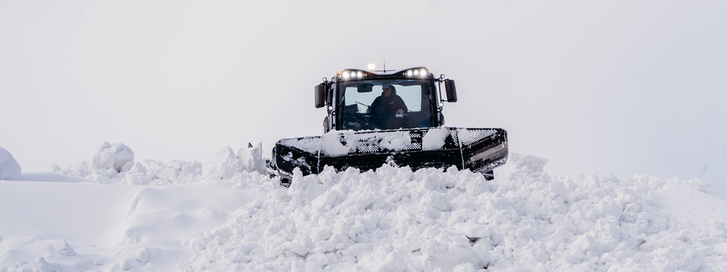 Snow groomer pushing out snow at Schuss Mountain