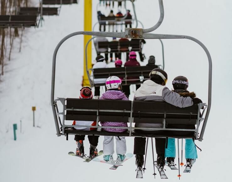 Back of a Young Boy, 2 Girls and Father on the yellow chairlift