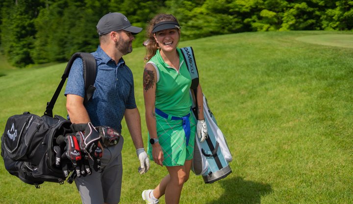 Man and Woman Walking with Clubs at Hawk's Eye GC