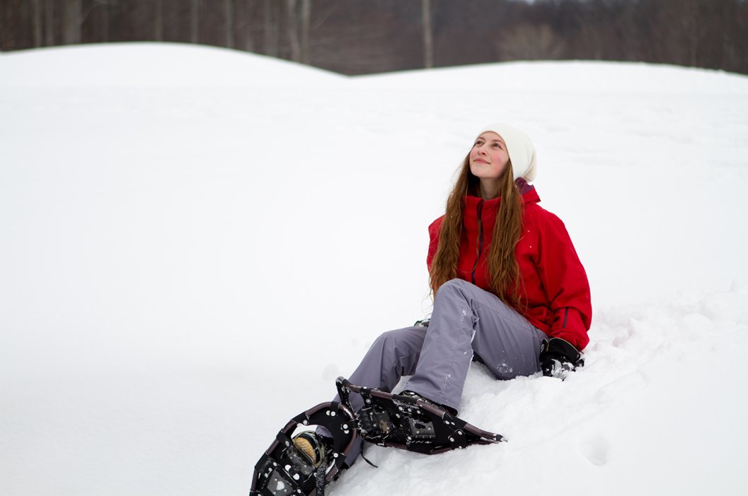 Snowshoeing Woman sitting in snow