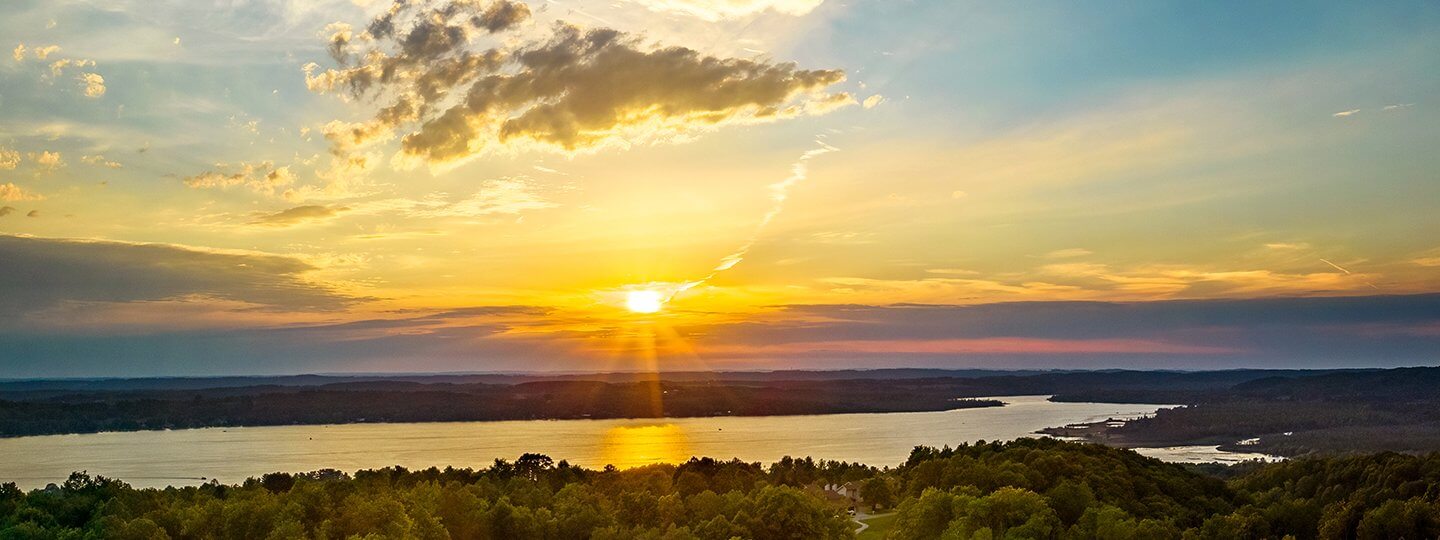 Sunset view of Lake Bellaire with trees in the foreground