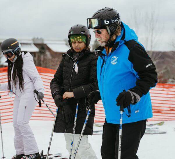 Ski Instructor standing with Adult Student