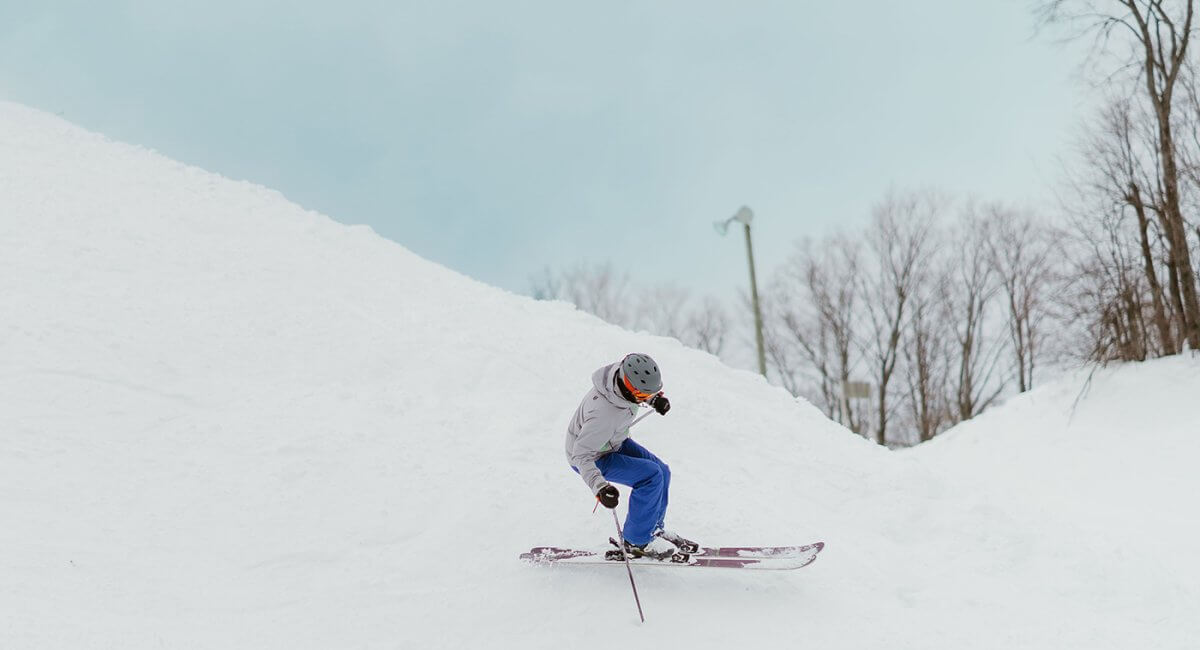 Skier in a gray coat and blue pants