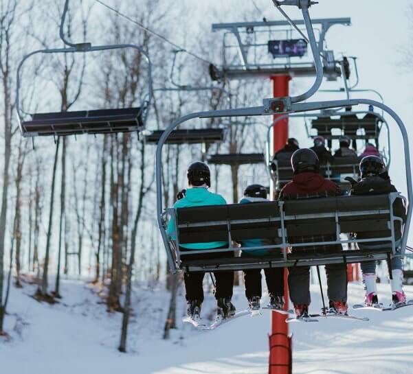 Family of Four Skiiers Riding Up the Red Chairlift