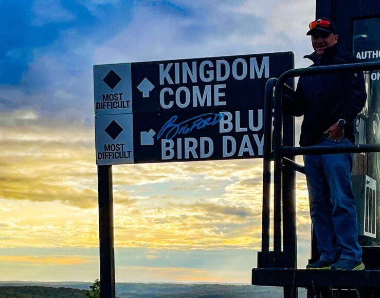 Pete Bigford standing next to Bigford's Bluebird Day Sign