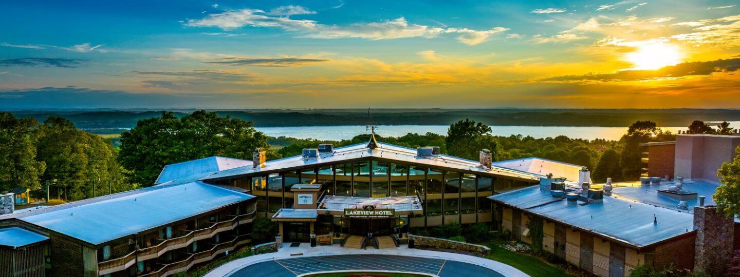 Front View of the Lakeview Hotel at Sunset, with Lake BEllaire and the sun setting behind it.