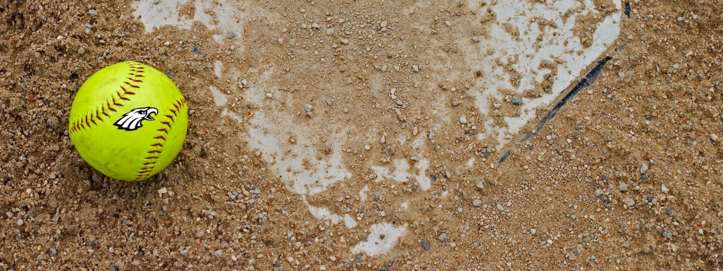 Softball with Bellaire Eagles Logo sitting on home plate
