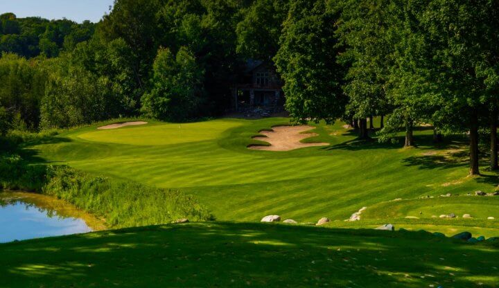 golf legend shanty cup a photo of a golf course fairway, green, pond, with trees in the background