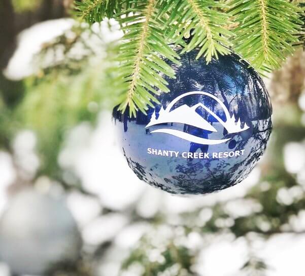 a holiday ornament with the words shanty creek resort hanging on a tree